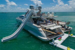 Luxury yacht with inflatable slide on deck by Yacht Scarlet Charters yacht rental Miami fun water adventure.